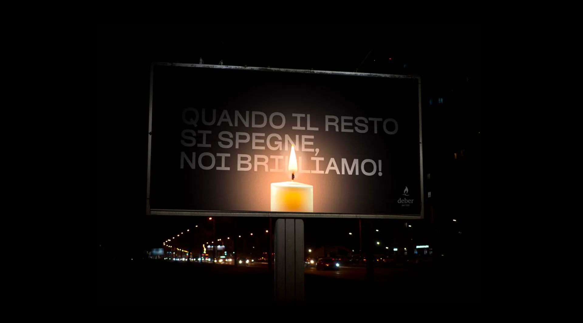 Billboard Deber illuminato di notte con una candela accesa