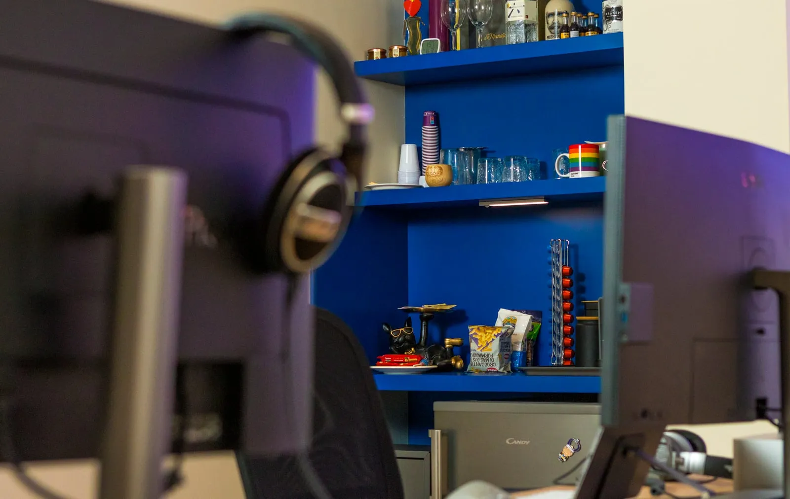 Area caffè con scaffali blu e macchina per espresso accanto alle postazioni