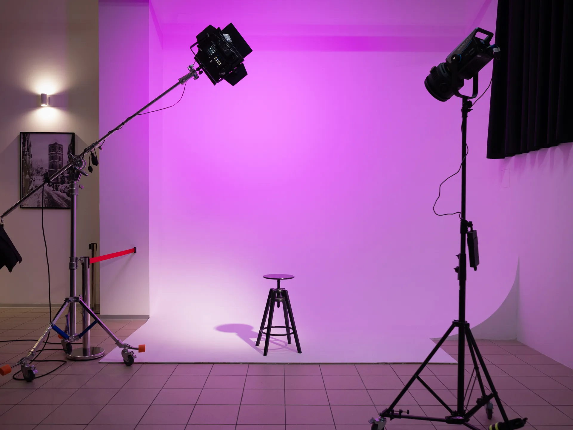 Limbo della sala posa con illuminazione viola, sgabello e luci da studio